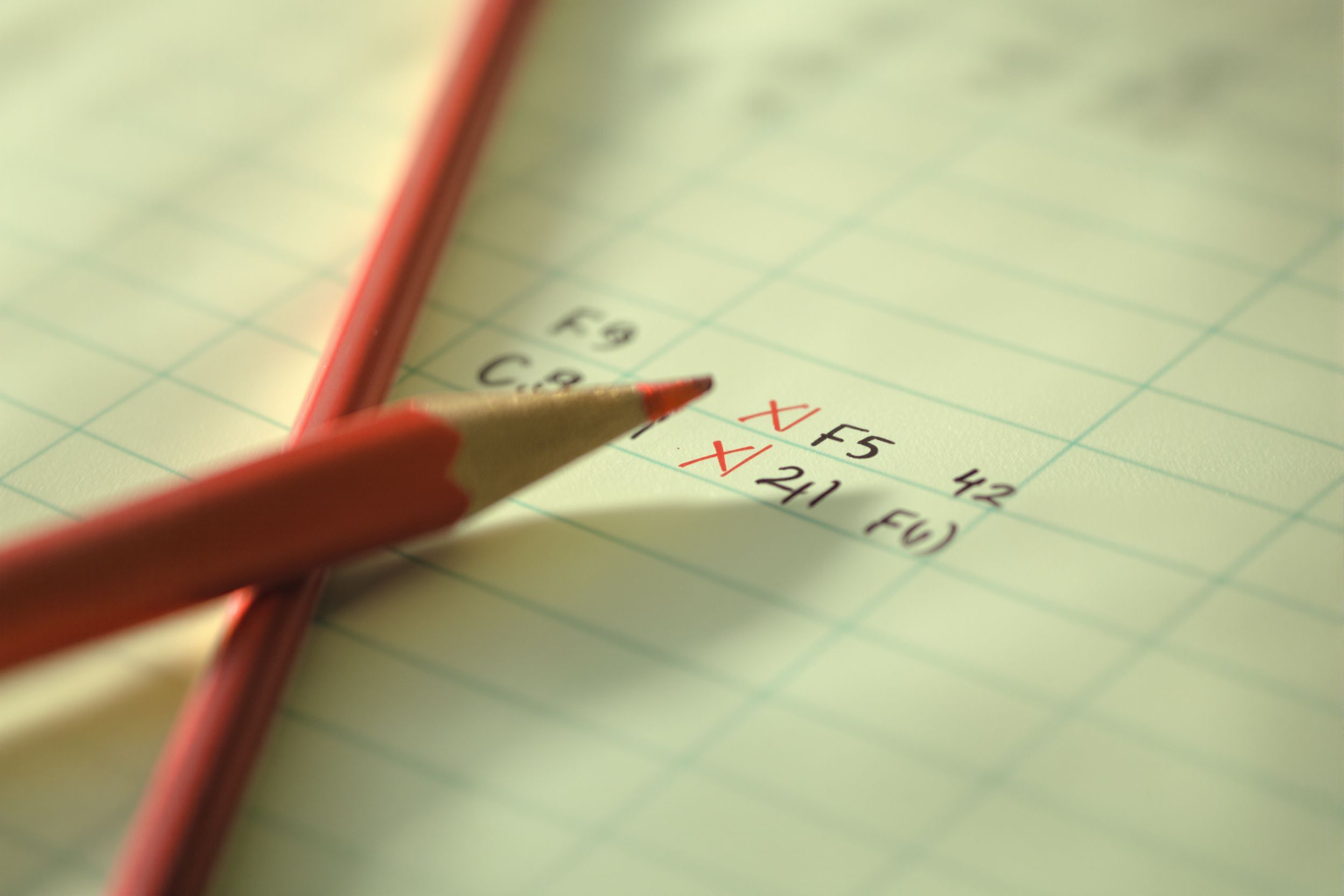 A green columnar pad with red pencil tick marks beside handwritten figures